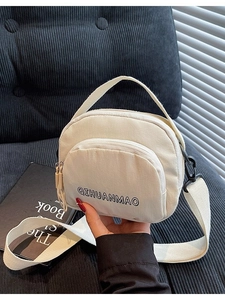 Chic beige canvas crossbody bag with black letter print and adjustable wide strap