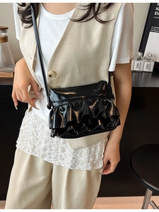 Fashionable black patent leather crossbody bucket bag with pleated double ruffle details
