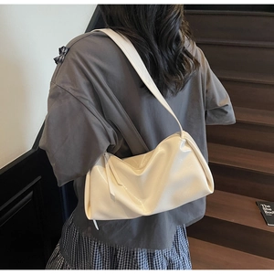 Detailansicht der cremeweißen PU-Leder-Schultertasche mit dekorativem langen Quasten-Zipper