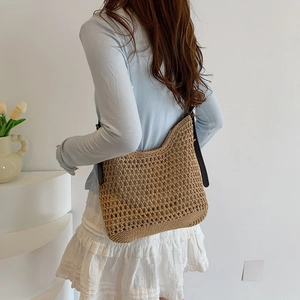 Chic khaki woven shoulder bag styled with leather straps on a model in a minimal setting