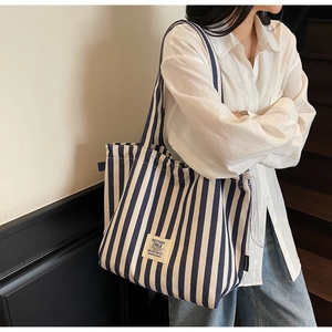 Detail of blue and white striped canvas tote bag showing the textured fabric and square label