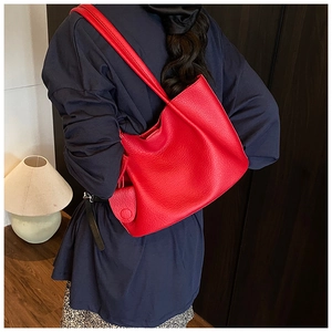 Detail of red pebbled leather tote bag with round coin purse on casual model