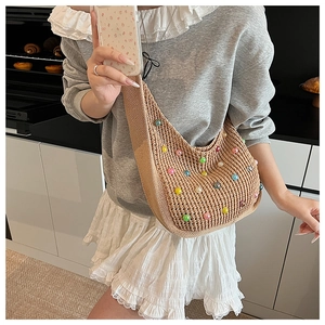 Detail of knit tote bag featuring colorful faux pearl embellishments and soft woven texture