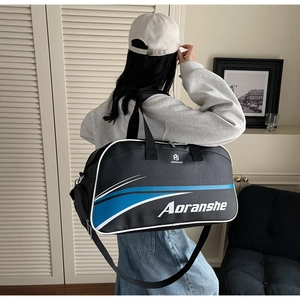 Detail of waterproof black fitness bag with blue and white stripes and sturdy handles