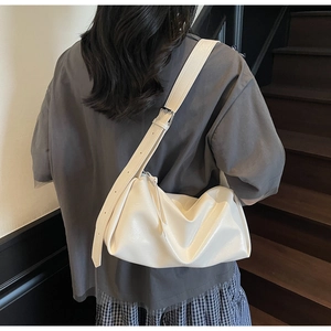 Minimalistische cremeweiße Weichledertasche an der Schulter in stilvollem Innenraum