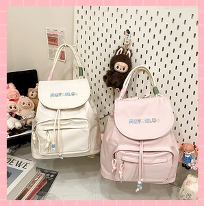 Detailed close-up of water-resistant nylon backpacks in soft cream and pink candy colors