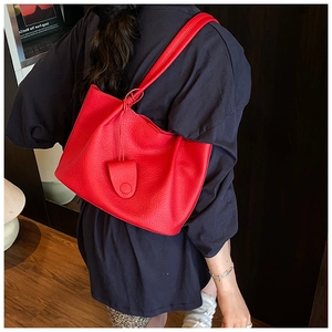 Detailed view of red lychee pattern tote bag with knotted strap and triangular pendant