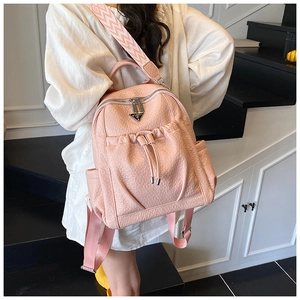 Pink faux leather backpack showing wide geometric pattern strap and metal triangle logo