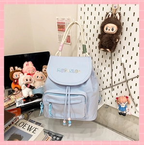 Detail of light blue nylon backpack with MUFANLUO embroidery and colorful rope straps