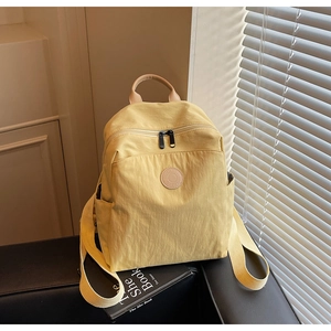 Detail view of yellow lightweight travel backpack with leather handle and nylon texture