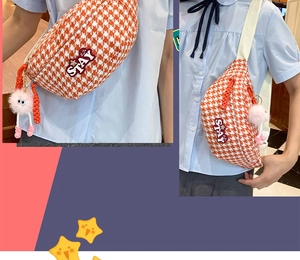 Détail du sac de poitrine pied-de-poule orange avec patch STAY et pompon rose
