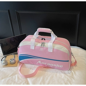 Pink fitness sports travel bag with white handles and shoulder strap on bed