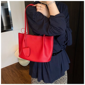 Detail of red lychee pattern leather tote bag with elegant texture and stitching