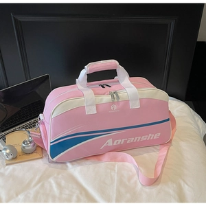 Detailed view of pink fitness bag with white handles and adjustable shoulder strap on white bedding