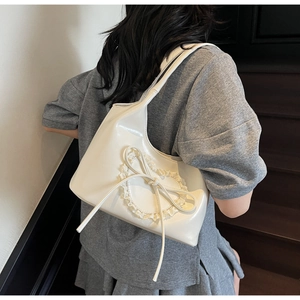 Dettaglio della borsa tote bianca con pizzo a cuore e fiocco in pelle PU lucida