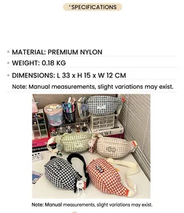 Détail du sac bandoulière en nylon à motif pied-de-poule avec un porte-clé en peluche