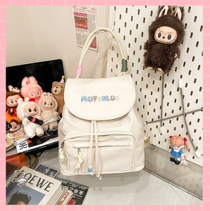 Close-up of white PU leather backpack with colorful embroidery and woven cord handle