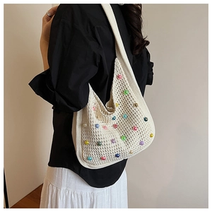 Detail view of cream crochet hobo bag with colorful beads and textured knit pattern