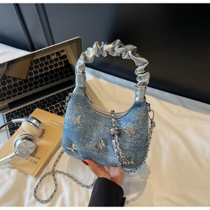 Detail of blue denim hobo bag with silver butterfly charms and scrunchie handle