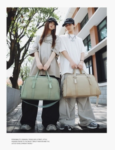 Detail of high-capacity travel bags in green and beige featuring dual handles and straps