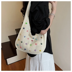 Detail view of beige knit shoulder bag with colorful pearls and openwork mesh texture