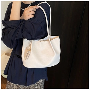 Close-up of cream white tote bag showing detailed lychee grain texture and side draping