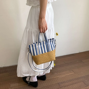 Close-up of blue striped canvas and straw woven base texture on summer tote bag