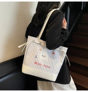 Détail du sac seau à rayures bleues avec imprimé phoque mignon et base en cuir élégante
