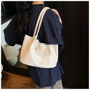 Detail of off-white lychee grain tote bag showing the unique knotted shoulder strap design