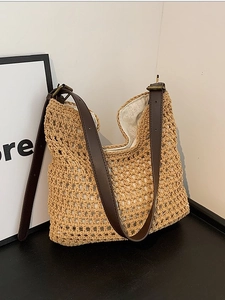 Woven straw shoulder bag with adjustable brown leather strap and fabric lining