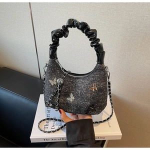 Detail of denim hobo bag featuring 3D silver metal butterflies and pleated handles