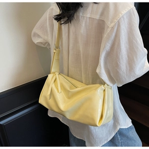 Detailansicht einer hellgelben Falten-Hobo-Tasche aus glänzendem Leder als Schultertasche