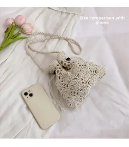 Vue détaillée du sac seau au crochet beige montrant la taille par rapport au téléphone
