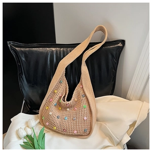 Detail shot of a bohemian hand-woven tote bag with colorful pearl beads on soft fabric