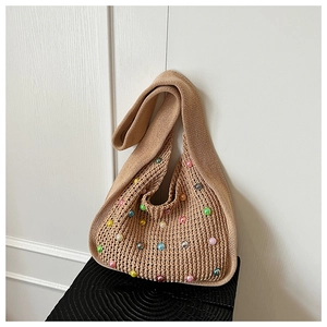 Detailed texture of hand-knitted beige shoulder bag featuring colorful faux pearl embellishments