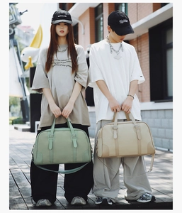 Outdoor shot of green and beige travel bags with dual handles and detachable straps