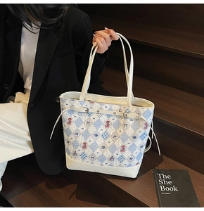 Détail du sac fourre-tout matelassé avec broderie d'ours et accents en cuir blanc