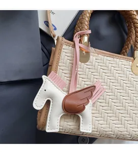 Détail du sac à main tissé avec poignées en cuir et accessoire de charme Pégase chic