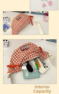 Détail de la capacité interne du sac bandoulière avec motif pied-de-poule orange et patch