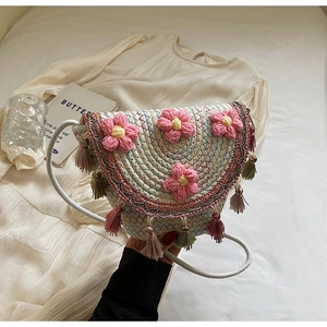 Detail of hand-woven crossbody bag with crochet flowers and colorful tassels