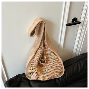 Close-up of beige knit beach bag featuring colorful beads and hollow mesh texture