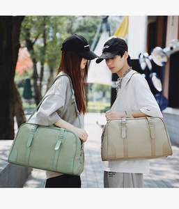 Detail of large travel handbags in light green and beige with lychee texture leather