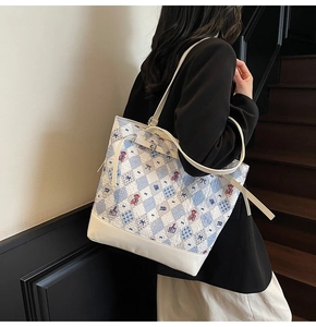 Détail du sac cabas à carreaux bleus avec motif ours et bordures en cuir crème