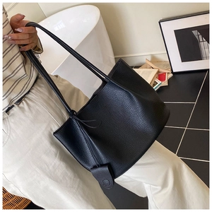 Detail view of the black pebble leather texture on a minimalist large capacity tote bag