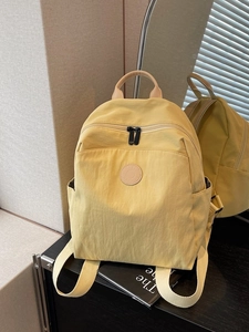 Light yellow lightweight water-resistant nylon backpack for women with multiple pockets