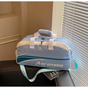 Detail of light blue sports bag with brand logo and durable handles on a sofa