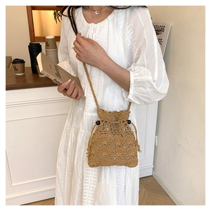 Détail du sac seau ajouré tissé à la main avec cordon de serrage et perles décoratives