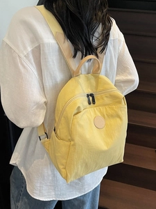 Bright yellow lightweight nylon backpack for women with leather trim and side pockets