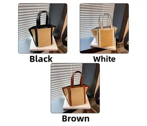 Detail view of woven straw beach tote bag in black, white, and coffee brown leather trim
