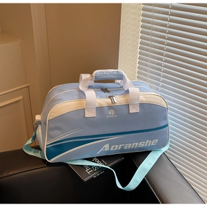 Close-up of light blue sports bag with durable fabric handles and detachable shoulder strap